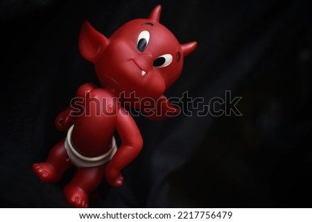 Cute Emotional Red Lovely Baby Devil Toy Figure Isolated On Dark Background