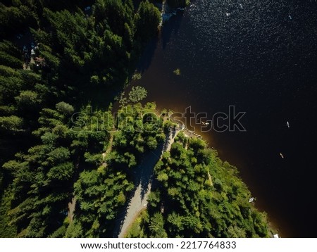 Top view of a large dark river, coniferous forest on a high bank, walking paths. Beautiful landscape. calm scenes. There are no people in the photo. Map, topography, geology, ecology.