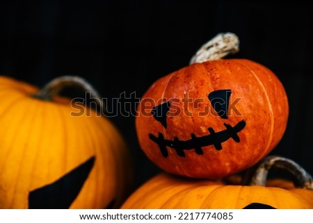 Close up portrait of bright orange  jack-o-lantern pumpkin face with black eyes and mouth as concept of Halloween