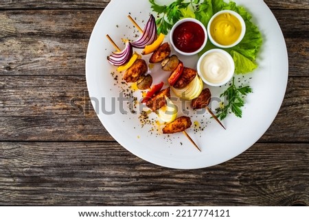 Chicken skewers - grilled meat with vegetables on wooden background 