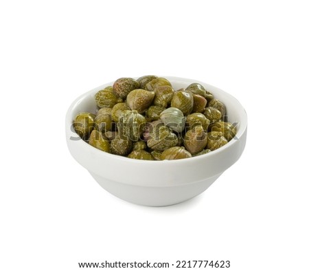 Pickled capers pile isolated. Marinated caper buds, small salted capparis in bowl, fermented food, pickled capers group on white background Royalty-Free Stock Photo #2217774623