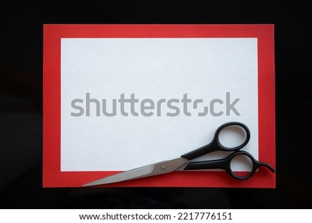 A white form for an ad in a barber shop with black scissors. Red frame on the barbershop ad. The announcement of a haircut.