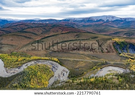 Engineer Creek and Dempster Highway in breathtaking autumn fall wilderness landscape seen from above on Sapper Hill, Yukon Territory, YT, Canada Royalty-Free Stock Photo #2217790761