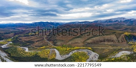 Engineer Creek and Dempster Highway in breathtaking autumn fall wilderness landscape seen from above on Sapper Hill, Yukon Territory, YT, Canada Royalty-Free Stock Photo #2217795549