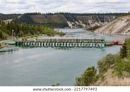 Lewes Dam control structure at end of Marsh Lake Yukon River regulates flow to hydro power station in Whitehorse YT Canada Royalty-Free Stock Photo #2217797493
