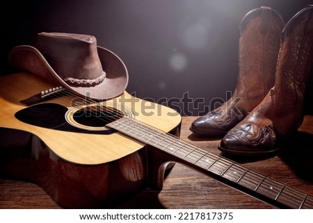 Country music festival live concert with acoustic guitar, cowboy hat and boots background Royalty-Free Stock Photo #2217817375