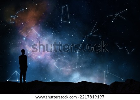 Zodiac signs and horoscope concept with black man silhouette on the earth looking at starry dark sky with constellations