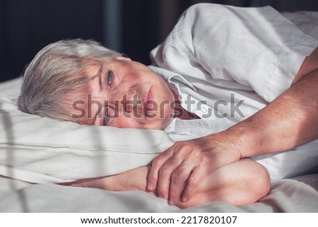 Sleepless middle-aged woman lying in bed suffers from insomnia sleep disorder cant sleep till morning, depressed elderly female looking upset thinking about life, health troubles concept Royalty-Free Stock Photo #2217820107