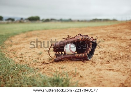 Sports, baseball gloves and field ball on dirt floor after game, competition or practice match for fitness, exercise or health. Softball pitch, training ground or baseball field equipment for workout Royalty-Free Stock Photo #2217840179