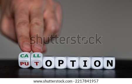 Hand turns dice and changes the expression 'put option' to 'call option'. Royalty-Free Stock Photo #2217841957
