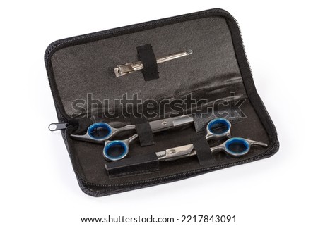 Set of two different professional stainless steel hairdressers scissors with blue removable rubber inserts in handles in the leathern case on a white background 
 Royalty-Free Stock Photo #2217843091