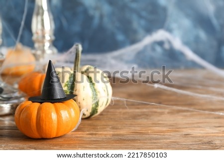 Halloween pumpkin with witch's hat on table, closeup