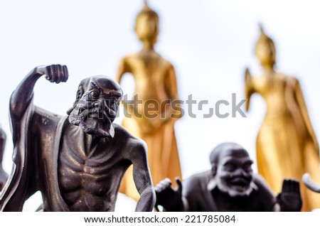 The black saint statue and the bured yellow buddha statue
