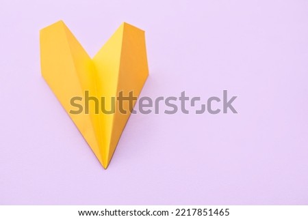 Yellow paper plane on lilac background