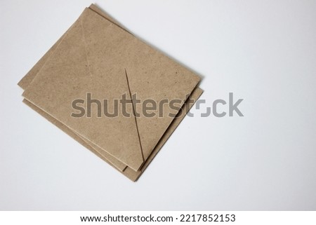 Brown Kraft Paper Envelopes Stacked on White Background. Minimal Business Mockup. 