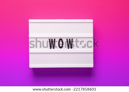 Lightbox with word Wow on pink background. Concept of expressing emotions and being excited