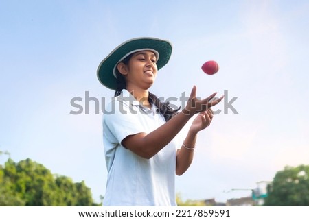 Indian Girl wearing cricket uniform catching the ball on the field