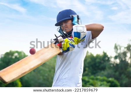 Indian Female cricket player wearing protective gear and hitting the ball with a bat on the field Royalty-Free Stock Photo #2217859679