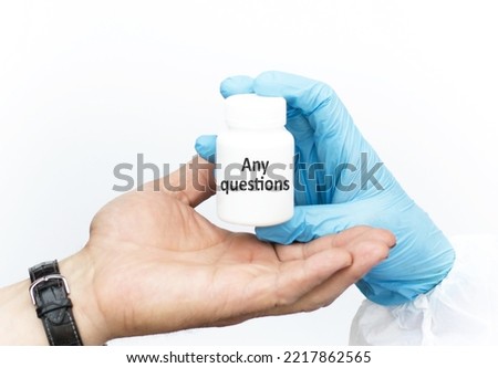 Any Questions text on a white jar on a light background of the doctor's and patient's hand