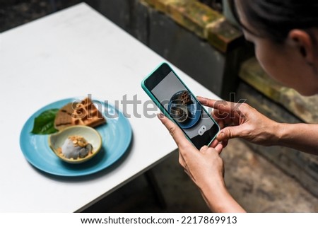 A woman taking picture of ice cream for advertisement and social media