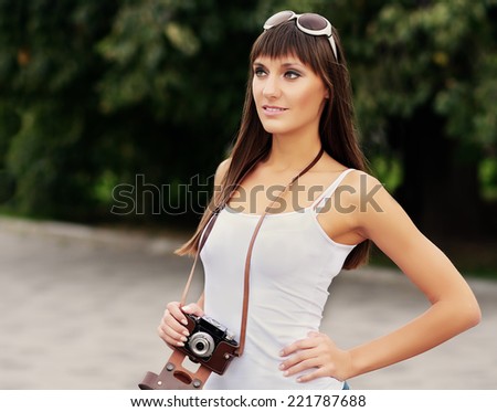 Young pretty woman outdoor summer closeup portrait in vintage style photo of photographer with camera