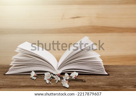 Fresh flowers on old book. Vintage book pages. Pretty bookish spring floral time aesthetic pic.