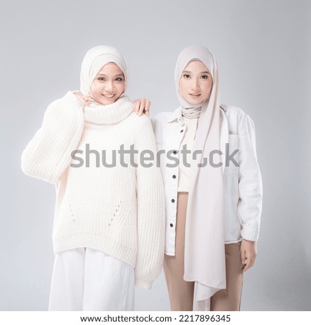 Portrait of two beautiful Muslim young women wearing modern and stylish casualwear with hijab isolated white studio background. Modern hijab fashion and beauty concept