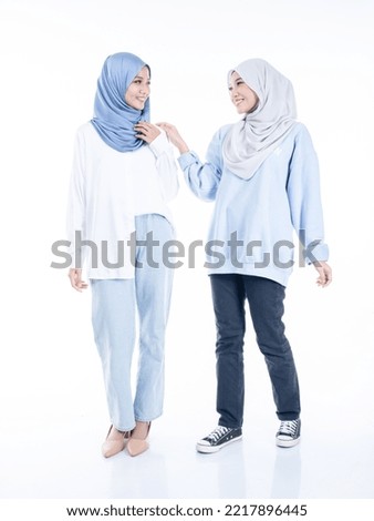 Portrait of two beautiful Muslim young women wearing modern and stylish casualwear with hijab isolated white studio background. Modern hijab fashion and beauty concept
