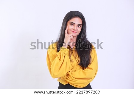 Closeup photo of amazing long hairdo lady looking in camera, deep thinking creative person arm on chin, finger on chin wearing yellow trendy top isolated on white color background. Girl has an idea