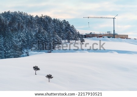 Building construction site and crane on snowcovered hill in winter at Zlatibor mountain in Serbia
