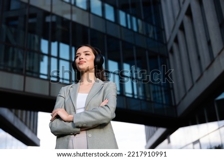 Attractive young lady on buisness centre background crossing her hands looking into distance going home after tired hard working day. Working process concept.