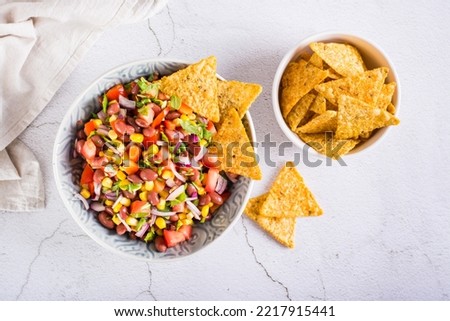 Mexican vegetable salad cowboy caviar and nachos in a bowl on the table. Top view