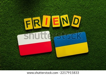 Flags of Poland and Ukraine on a green lawn. friendship and partnership in war. support background. Top view.