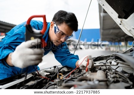 Auto mechanic concept.  Asian mechanics are using tools to check car safety in garage, maintenance of damaged parts in garage. Maintenance work. Concept of repair service.
