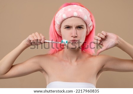 Young pink-haired girl having a toothache and looking unpleased