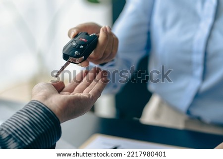 of the representative Hold the car keys to the new owner after signing the leasing contract in the car sales contract document.