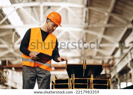 Worker at the steel factory checking the material
