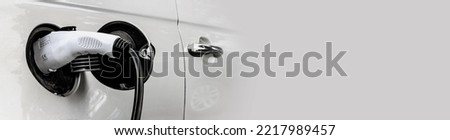 Electric car at the charging station background with free space in grey color for the site. Ecology. Eco-friendly transport. Royalty-Free Stock Photo #2217989457