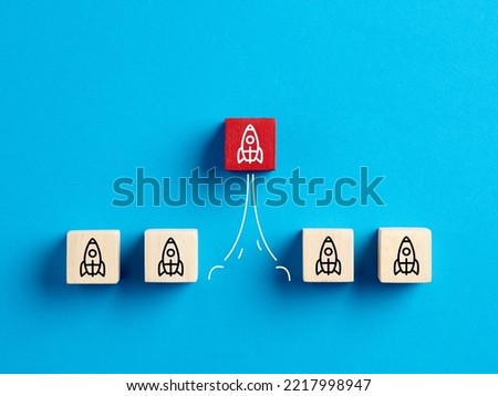 Business start up, development, innovation, product launch and leadership concepts. Rocket icons on wooden blocks with one launched rocket.