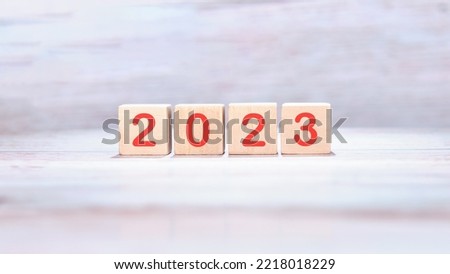 Wooden cubes with the inscription 2023 on a light background.