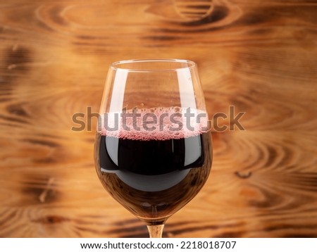 Glass of wine on a wooden background. Glass goblet with wine.