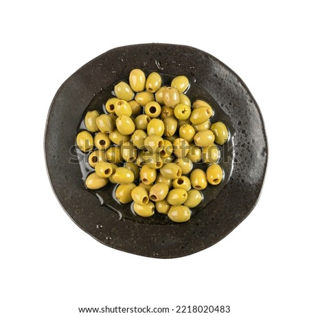 Green Pickled Olives on Black Plate. Pitted Fermented Olives, Marinated Mediterranean Snack, Olive Pickles on White Background Top View