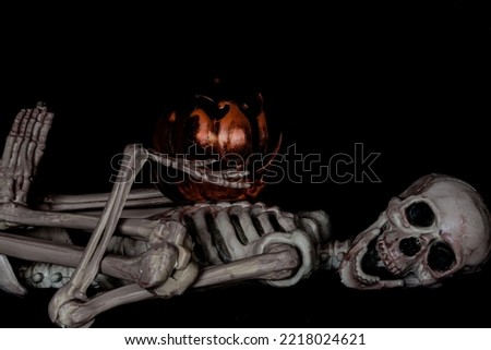 Halloween skeleton  lying  down  with  pumpkin