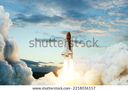 Spaceship lift off. Space shuttle with smoke and blast takes off into space on a background of blue sky.