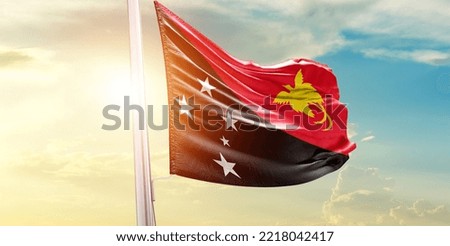 Papua New Guinea national flag waving in beautiful clouds.