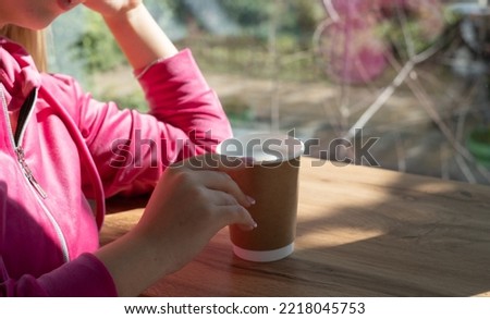 a girl holds a cup of coffee in her hands