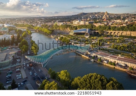 Panoramic aerial view of downtown Tbilisi, Georgia. In the foreground is the Peace Bridge over the Mtkvari River. Royalty-Free Stock Photo #2218051943