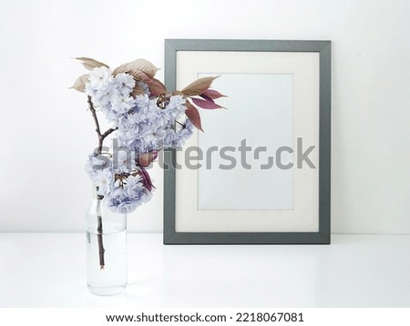 Frame mockup with flowers. Portrait or poster frame mockup. Empty white frame mockup for presentation artwork