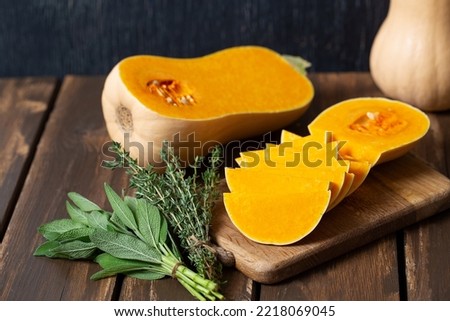 Fresh butternut squash with thyme and sage on a wooden surface.  Butternut Pumpkin . Healthy food concept.