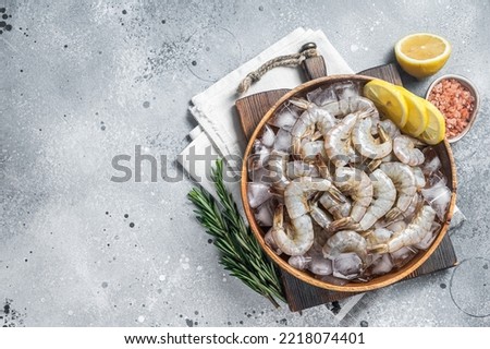 Uncooked Raw peeled tiger white shrimp prawn. Gray background. Top view. Copy space. Royalty-Free Stock Photo #2218074401